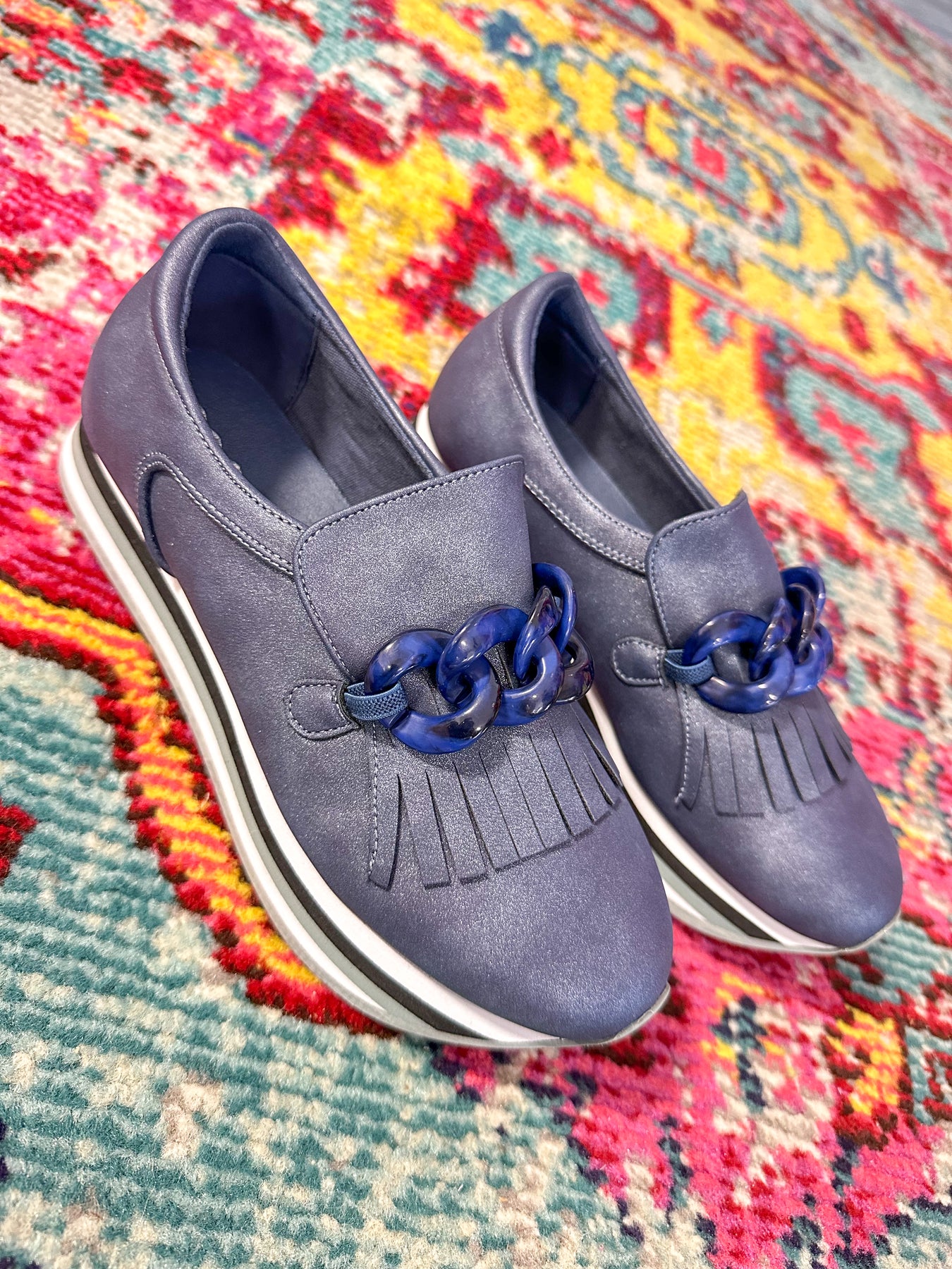 Pictured is a pair of navy blue loafer style shoes. 