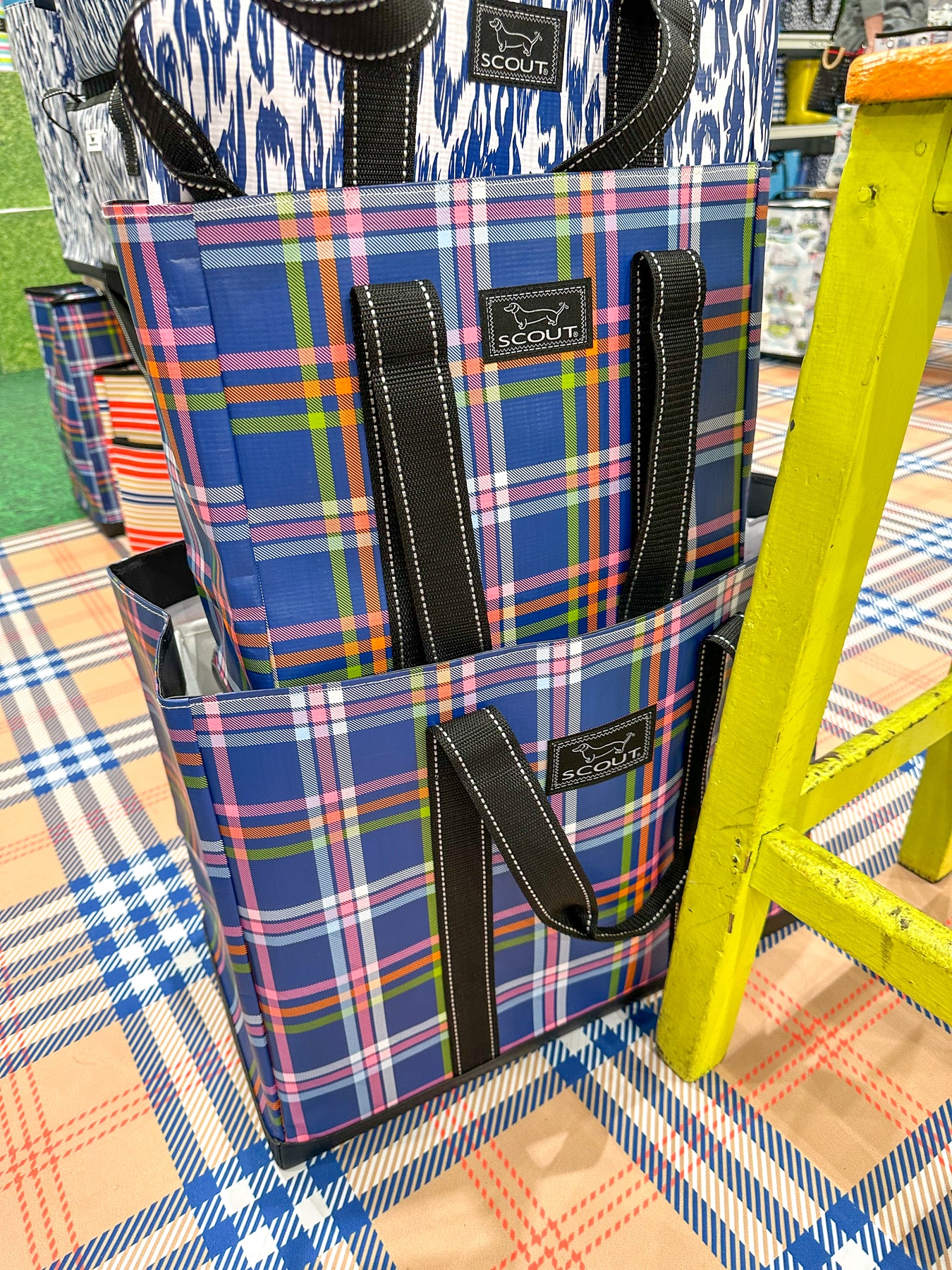 Pictured are two navy blue plaid tote bags. 